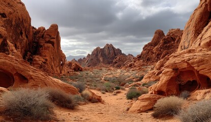 A desert landscape with dramatic reddish rock formations.  A path winds through the landscape.  Clouds gather overhead