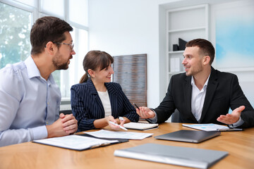 Couple having meeting with business consultant at table in office