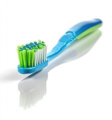 A blue and green toothbrush angled against a white background. 