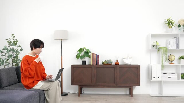 女性、ノートパソコン、リビングルーム、リラックス、くつろぐ、PC、動画、検索、インターネット、オンライン、web、wi-fi、IT、DX、無線、ソファー、座る、カジュアル、主婦、ミドルエイジ、30代、40代、日本人、普段着、くつろぎ、ニュース、コピースペース、広告、通信、デジタル、情報、リサーチ、計画、休憩、コーヒー、カフェ、趣味、楽しみ、インテリア、住宅、暮らし、ライフスタイル、住まい、部屋、家
