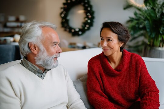 Mature caucasian man and hispanic woman smiling in festive living room
