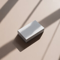 Elegant stack of white business cards casting shadows on neutral background surface