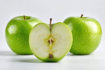 Three green apples, one halved, on a white background