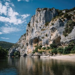 Rocky riverside cliffs under a partly cloudy sky
