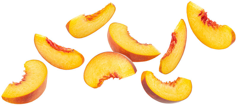 Falling peach slices isolated on white background with clipping path, falling nectarine pieces