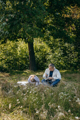 Adult father and little daughter are walking in the park
