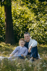 Adult father and little daughter are walking in the park