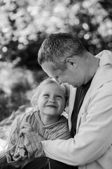 Adult father and little daughter are walking in the park