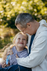 Adult father and little daughter are walking in the park