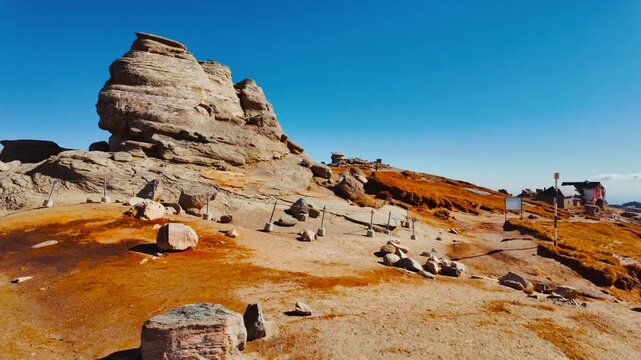 Mushroom shaped and anthropomorphic rock formations in a beautiful mountain range, displaying weathered stone columns, rounded caps, and curious silhouettes, under open sky across rugged terrain
