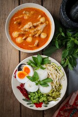 Kanomjeen namya krati ,Rice vermicelli with minced fishes ,Chicken feet,meatballs and coconut milk in red curry on ceramic plate side dish with vegetables and boiled egg