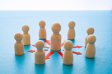 Obraz premium Concepts of communication, leadership, guidance, hierarchy, connection, expressed with a wooden figure and red arrows pointing to other figures.