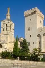 Palais des Papes (Palace of the Popes) in Avignon, France and a gilded statue of the Virgin Mary atop the cathedral tower.