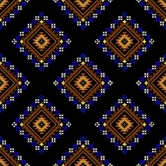Intricate geometric ethnic pattern with earth-toned diamonds and blue cross-stitch details on a black background, evoking a traditional textile look.

