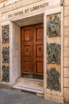 The door decorated with black sculptures of the Casa del Mutilato in Massa, Italy