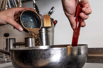 Captures the dynamic motion of adding seasoning to a dish. This action shot conveys authenticity and the passion of cooking, perfect for food blogs, recipes, and culinary content.