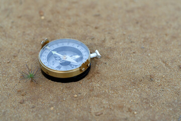 Metal tourist compass on the sand on the beach closeup