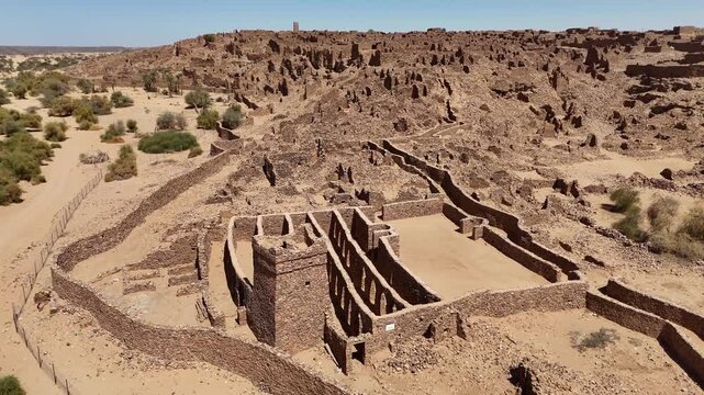 Aerial drone view of preserved stone fortress and courtyard in the ancient ruins of Ouadane, Mauritania, UNESCO World Heritage site in the Sahara desert