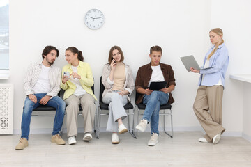 Fototapeta premium People waiting in queue on chairs indoors