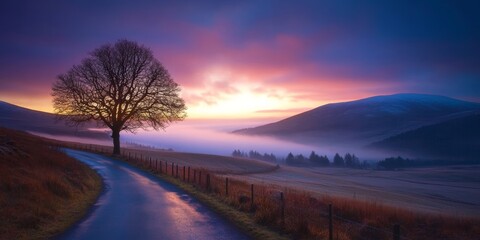 Serene Evening Road Meandering Through Misty Mountains and Silhouetted Trees at Sunset Glow