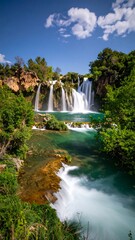 Obraz premium Waterfall cascading down rocks, lush green forest