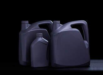 Black oil gallon or lubricant barrel or motor oil bottle isolated on black and dark background.
