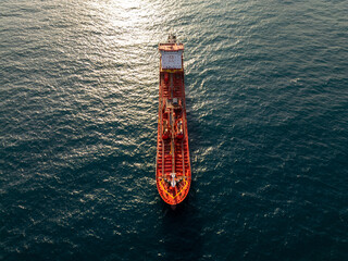 Top-down aerial video of a red oil tanker ship floating in the open sea. Industrial marine vessel...