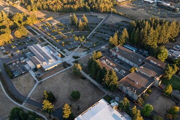 Aerial drone picture of a modern college building in Oregon City with rooftop solar panels, showcasing renewable energy technology and sustainable architecture in an academic campus setting