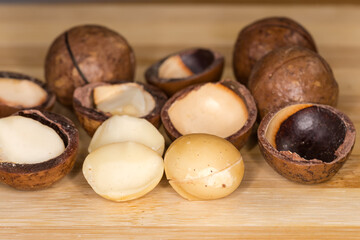 Shelled and whole macadamia nuts with sawn shell, front view