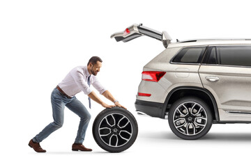 Man pushing a spare car tire