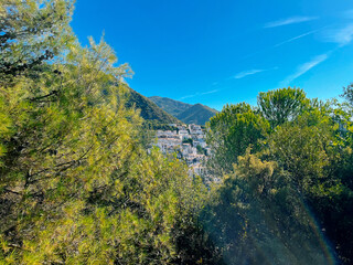 Typical white Andalucian Spanish town on slope of a mountain under clear blue sky. View through...