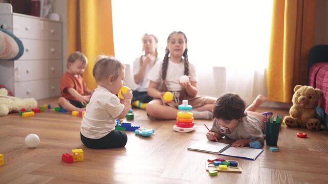 lifestyle little children play at home. happy and full of joy childhood, children's dream concept. a group of children of different ages spend time playing together, various colorful toys lie nearby
