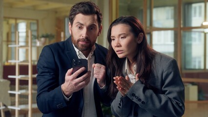 Frustrated praying business woman man using mobile phone lost money deal fail offer at office...