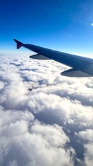Fototapeta premium Airplane wing over fluffy clouds
