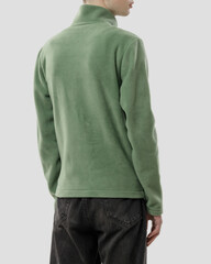 Three-quarters back view of a young man wearing a pistachio green fleece jacket, standing in a studio against a simple white background. © Vitalii
