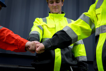 Fototapeta premium Collaboration and teamwork are essential in workplace, as shown by team workers in bright safety gear engaging in fist bump. This moment symbolizes unity and mutual respect
