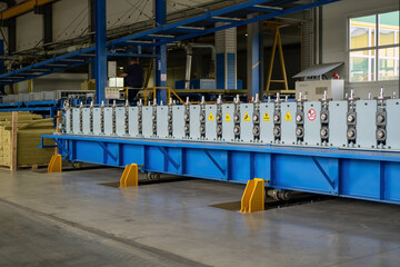Part of a coil slitting or cut-to-length or roll forming line. A machine that form flat coil metal into shaped profiles.