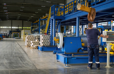 Industrial equipment for working with coil metal. Decoiler holds and unwinds metal coil. Slitting or cut-to-length line - cut coil metal into strips. Crane with hook - used for moving coils.