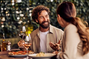 Couple Enjoying Dinner at a Cozy Outdoor Restaurant with Wine and Conversation