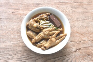 boiled chicken leg and feet couple blood with bean sprout in herb brown soup on bowl
