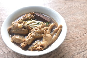 boiled chicken leg and feet couple blood with bean sprout in herb brown soup on bowl