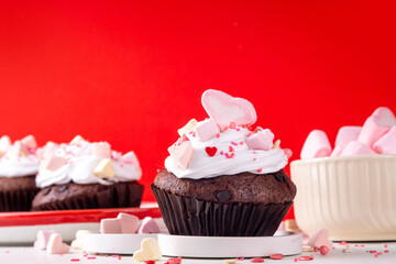 Valentine day tasty cupcakes treat with whipped cream, heart marshmallow and sugar sprinkles