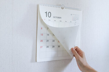 10月のカレンダーをめくる手元