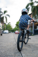 Little school boy wnjoy ride bicycle in town house city