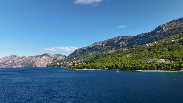 Breathtaking aerial video of the Makarska Riviera with the majestic Biokovo mountains towering over Brela beautiful coastline