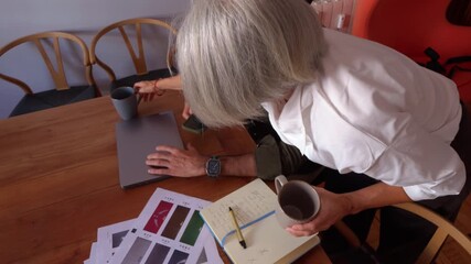 Mature creative couple working together on a design project at home