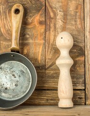 Old pan and wooden utensil on rustic wood