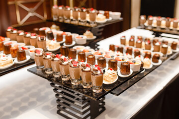 Elegant Dessert Buffet Table with Glasses of Chocolate Mousse and Berry Topping