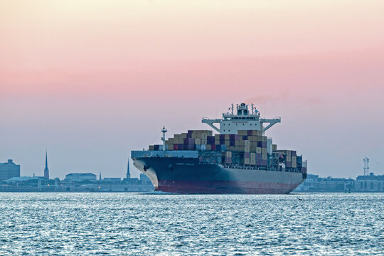 The Post Panamax-class container ship Hubert Schulte sails out of Charleston Harbor, SC, USA on September 16, 2025, with fading sunset in the background..