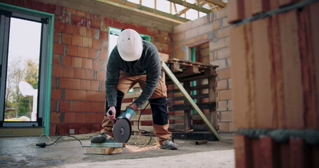 Construction worker operating angle grinder, sparks flying from metal cutting, focused on task,...